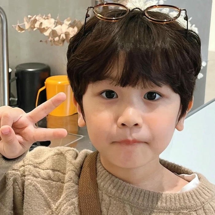 Ảnh em bé dễ thương bé trai giơ tay chữ V