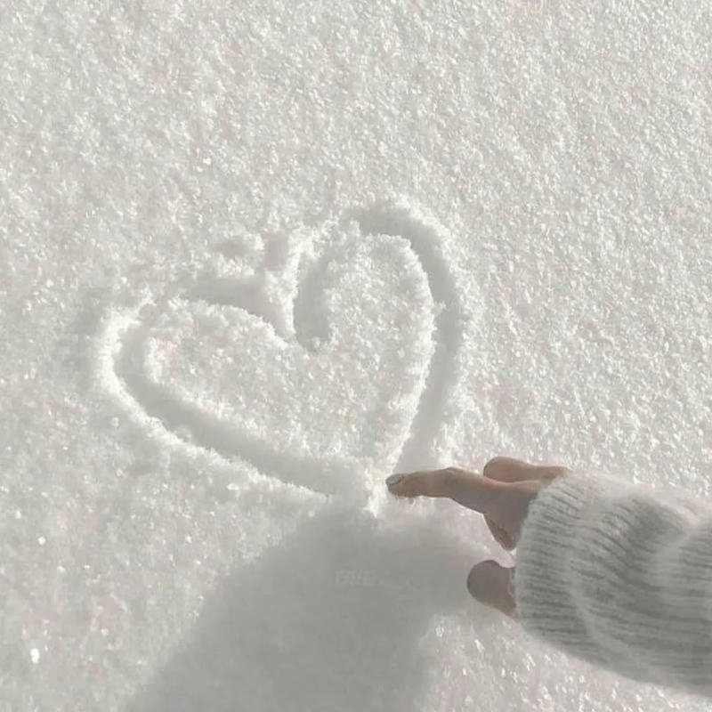 Hình bàn tay vẽ trái tim trên lớp tuyết trắng xóa