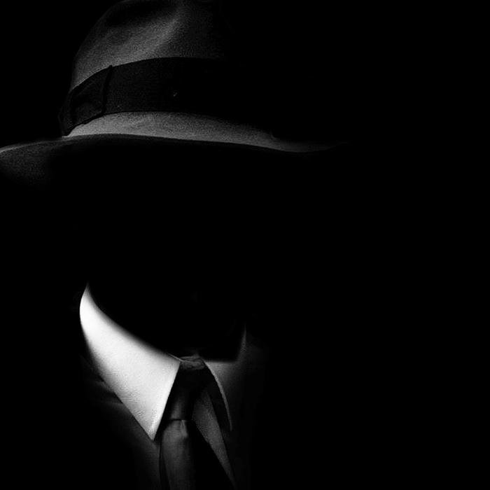 Hình nền đen người đàn ông đội mũ bí ẩn giấu mặt