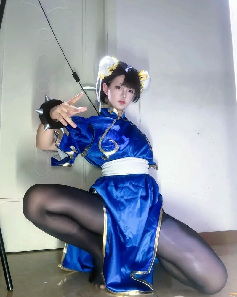 ảnh cosplay chun li ngồi trên hộp vàng cầm gậy