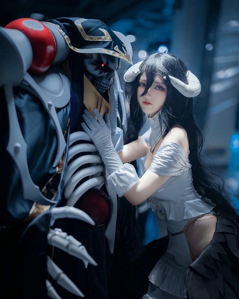Albedo cosplay đứng cạnh mô hình xương khổng lồ