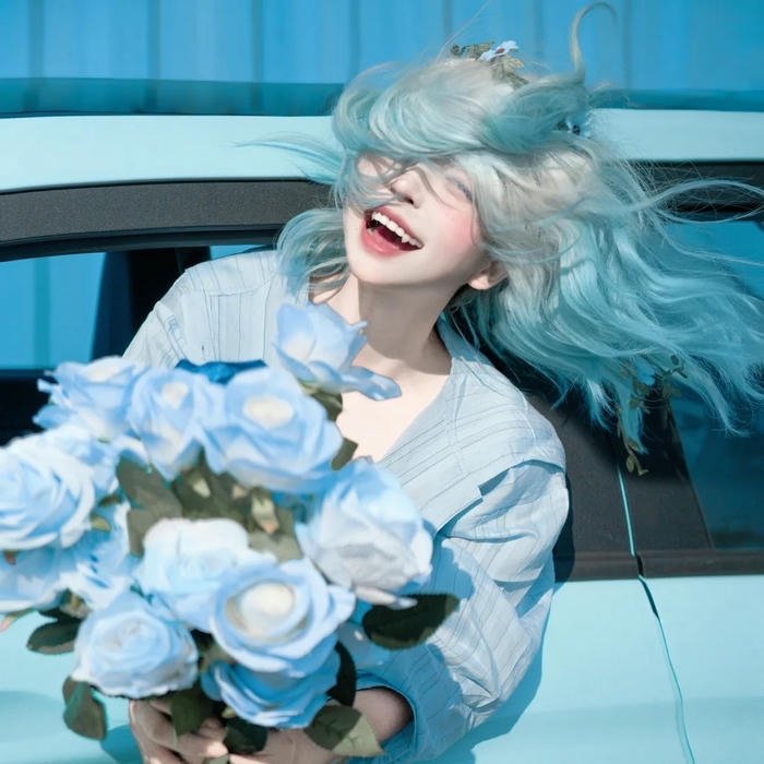 Ảnh avatar màu xanh dương cô gái cười rạng rỡ bên hoa