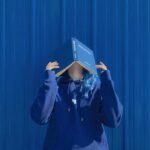 Ảnh avatar màu xanh dương người che mặt sau cuốn sách