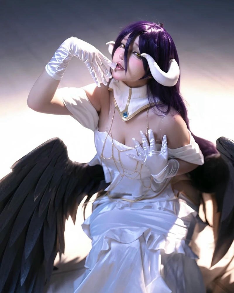 Cosplay Albedo váy trắng cánh đen ngồi bệt trên sàn