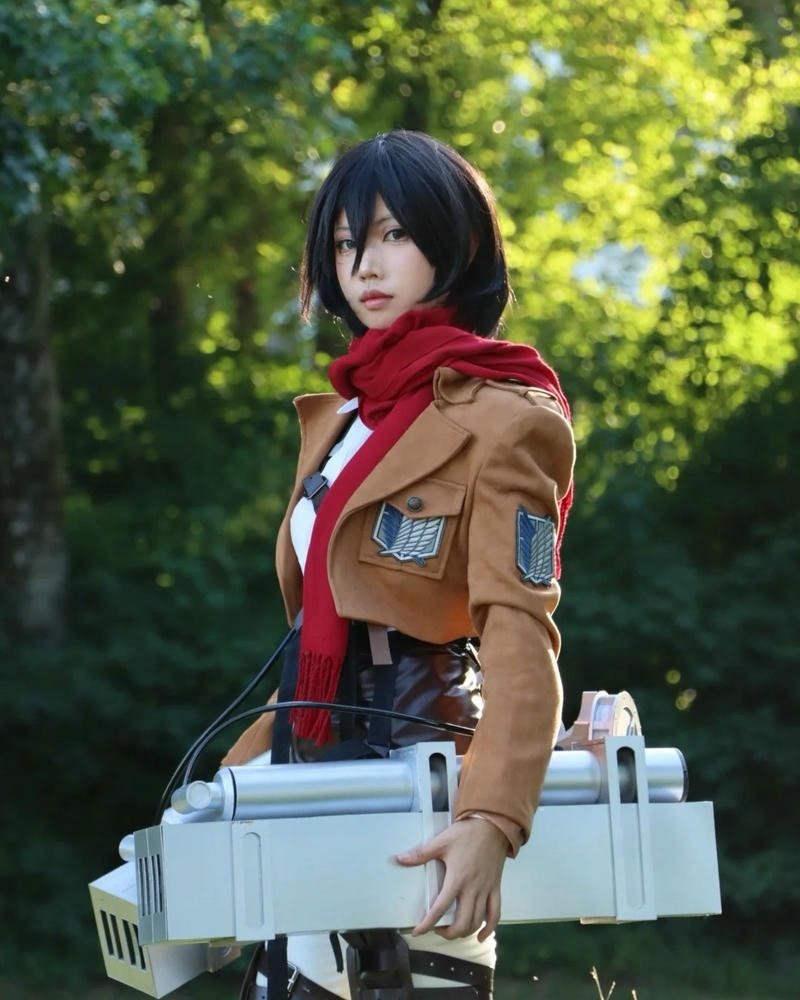 Cosplay Mikasa cầm kiếm đứng trong rừng cây