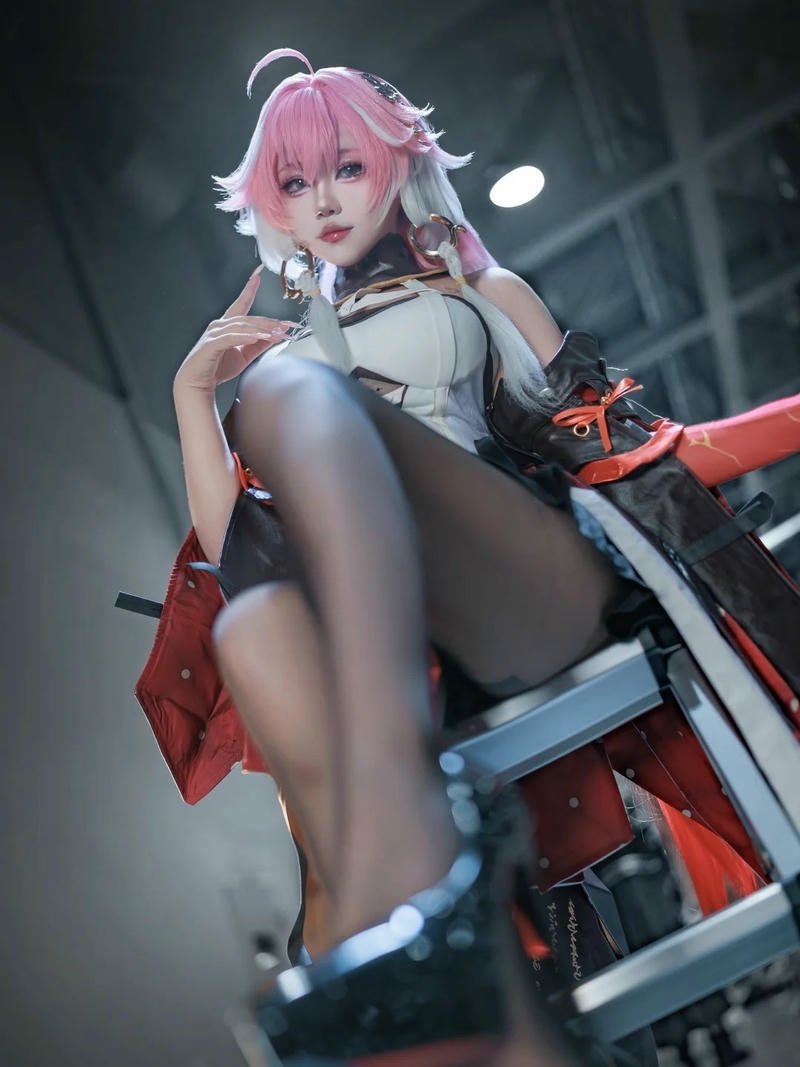 Cosplay Trung Quốc tóc hồng ngồi ghế tạo dáng ngầu