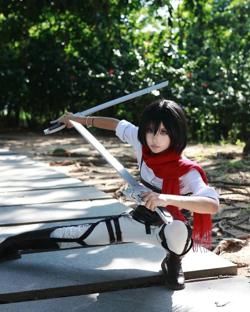 Mikasa Ackerman ngồi xổm trên bậc thềm cầm kiếm