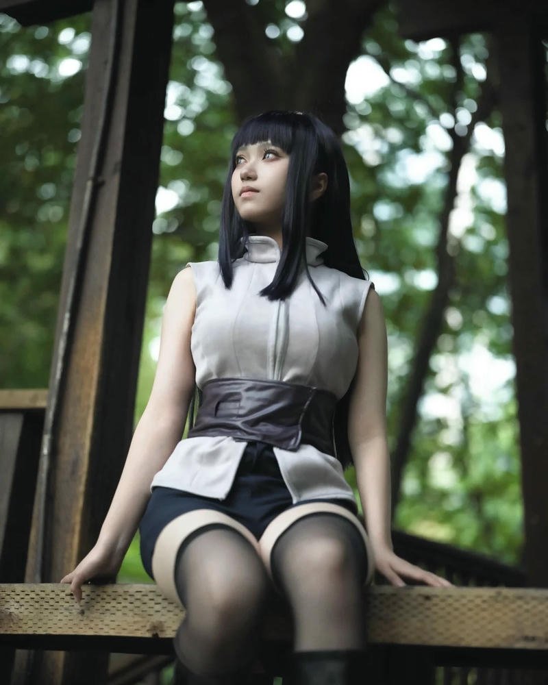 hinata tóc dài ngồi trên ghế gỗ ngoài trời